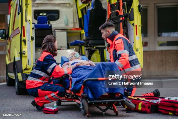 rescuers taking care of senior woman patient. - stretcher stock-fotos und bilder