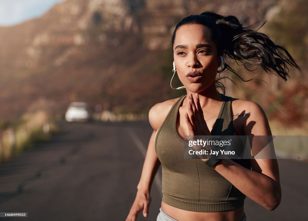 Respiração, música e mulher correndo na rua para fitness, treinamento e maratona nas montanhas. Esportes, treino e corredor na estrada com um podcast enquanto faz um exercício ao ar livre na Alemanha