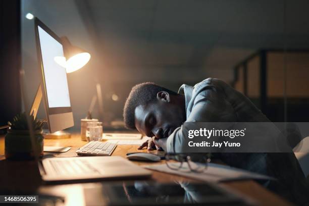 tired black man, sleeping and burnout from working at night by office desk suffering stress or overworked. exhausted african american male asleep on table by computer for long work hours at workplace - working overtime stock pictures, royalty-free photos & images
