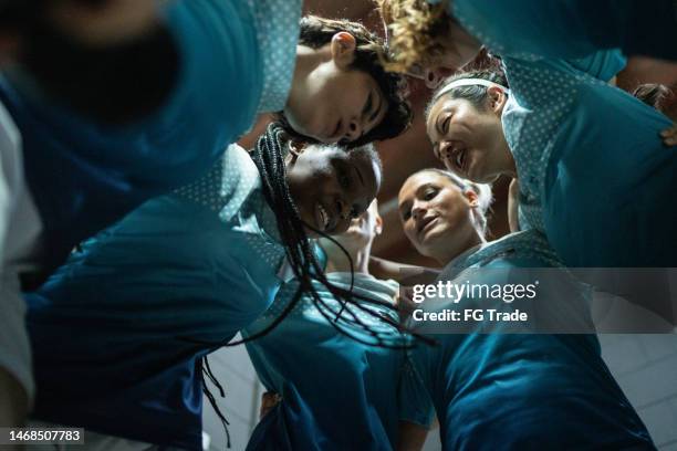 female soccer team huddling in the locker room - team talk changing room stock pictures, royalty-free photos & images