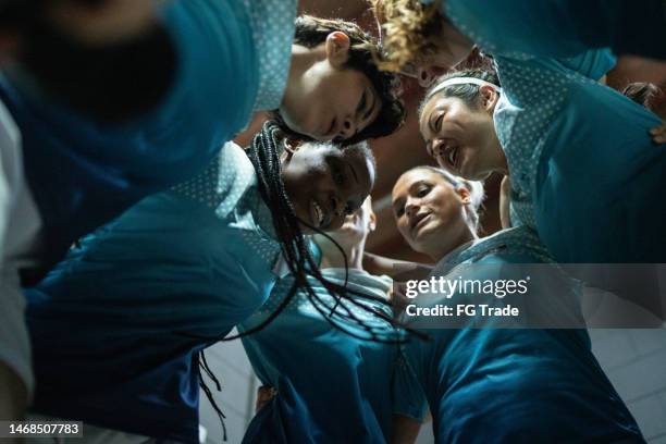 female soccer team huddling in the locker room - soccer locker room stock pictures, royalty-free photos & images