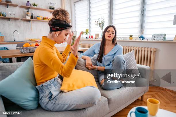 dos mujeres jóvenes discutiendo en casa - friends argue fotografías e imágenes de stock