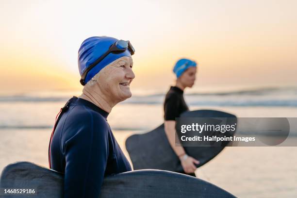 daughter with her elder mother in neoprene enjoying time at ocean. - old people diving stock pictures, royalty-free photos & images