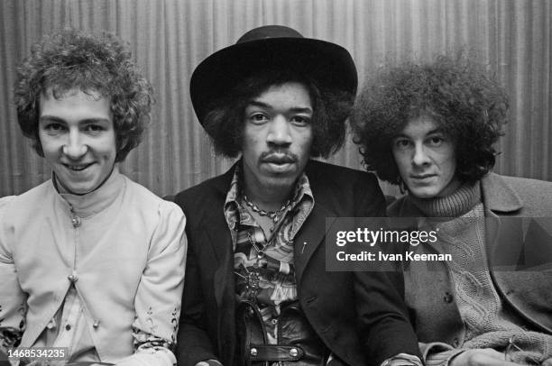 American guitarist and singer Jimi Hendrix seated in centre with, on left, drummer Mitch Mitchell and, on right, bassist Noel Redding of the Jimi...