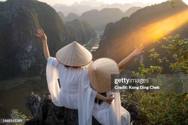 asian chinese mother and daughter wearing vietnam traditional clothes and hat at ninh binh famous place, vietnam - hanoi stock pictures, royalty-free photos & images