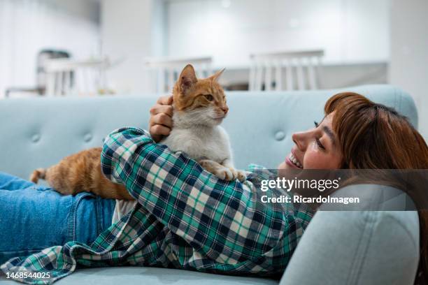 woman spending time with her cat at home - pats stock pictures, royalty-free photos & images