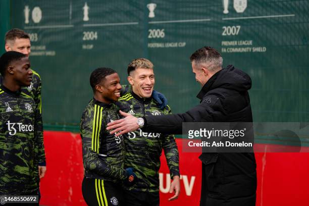 Tyrell Malacia, Lisandro Martinez of Manchester United greets former player Robin van Persie ahead of a first team training session ahead of their...