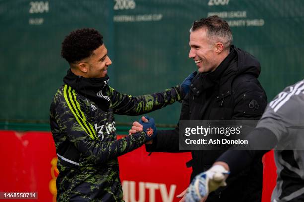 Jadon Sancho of Manchester United greets former player Robin van Persie ahead of a first team training session ahead of their UEFA Europa League...