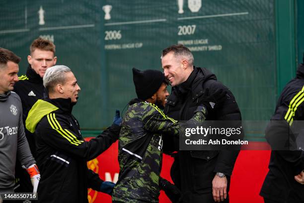 Antony, Fred of Manchester United greets former player Robin van Persie ahead of a first team training session ahead of their UEFA Europa League...