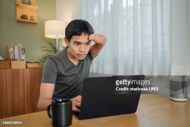 handicapped man calculating personal expenses at home. - tax return stockfoto's en -beelden