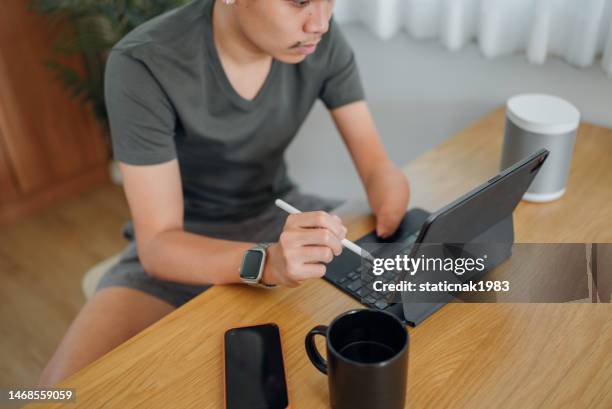 handicapped man calculating personal expenses at home. - account manager stock pictures, royalty-free photos & images