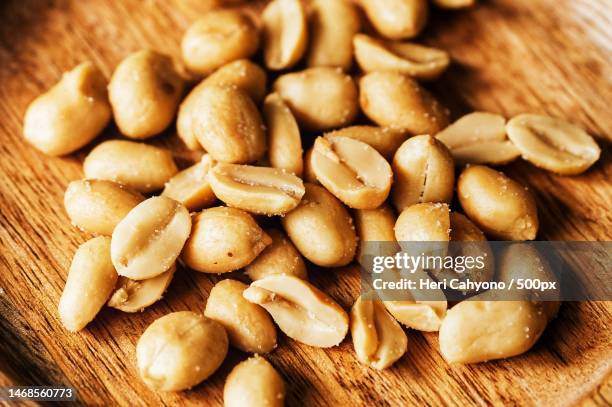 onion salted peanuts on a brown chopping board,indonesia - peanuts fotografías e imágenes de stock