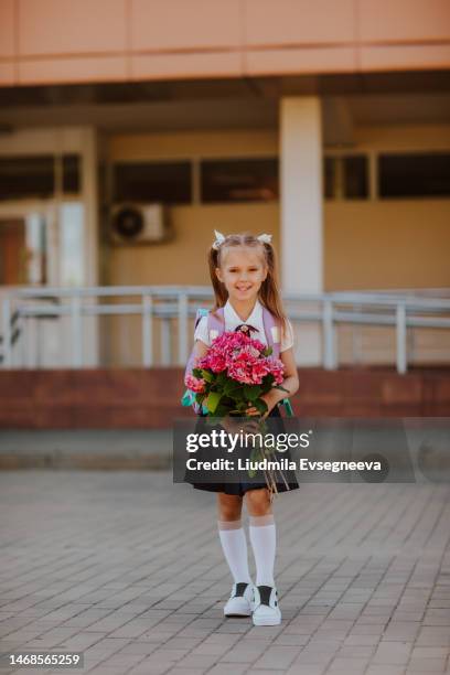 girl posing with pink bouquet of flowers in the school yard - school bell stock pictures, royalty-free photos & images