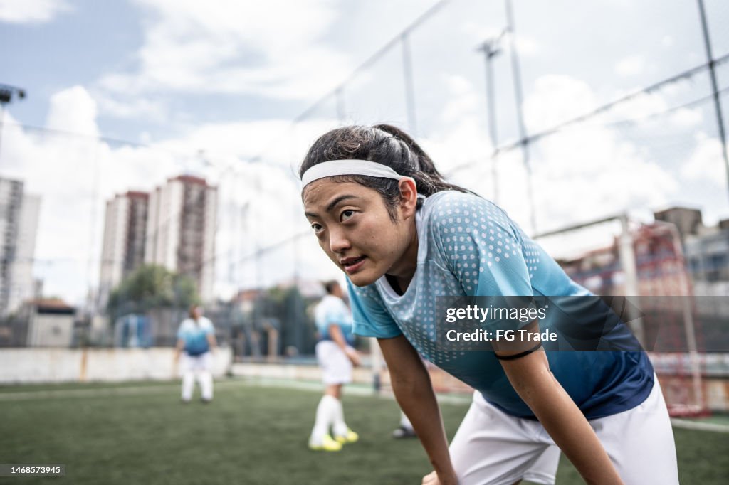 Tired female soccer player in the field