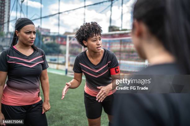 female soccer team captain talking to the team before the match - team captain stock pictures, royalty-free photos & images