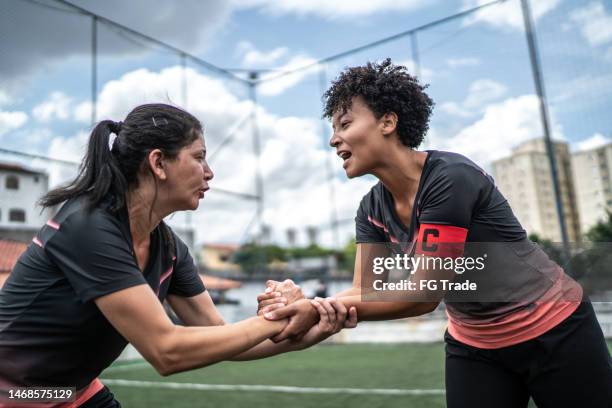 female soccer team captain encouraging colleague before match - team captain sport stock pictures, royalty-free photos & images