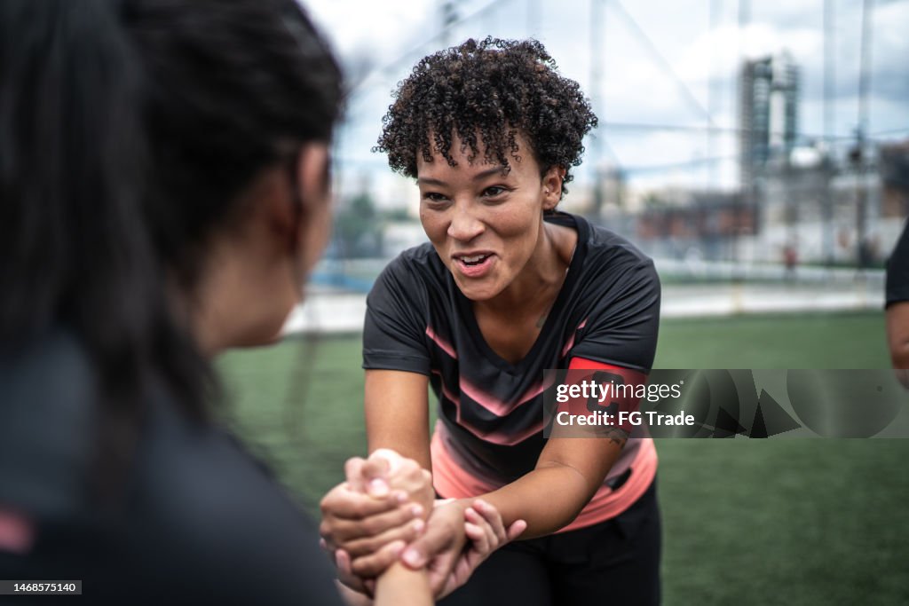 Female soccer team captain encouraging colleague before match