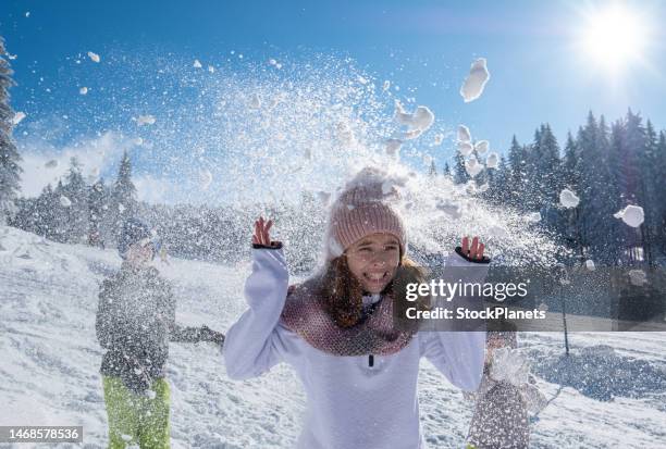 brüder werfen schneebälle auf schwester. - schneeball stock-fotos und bilder