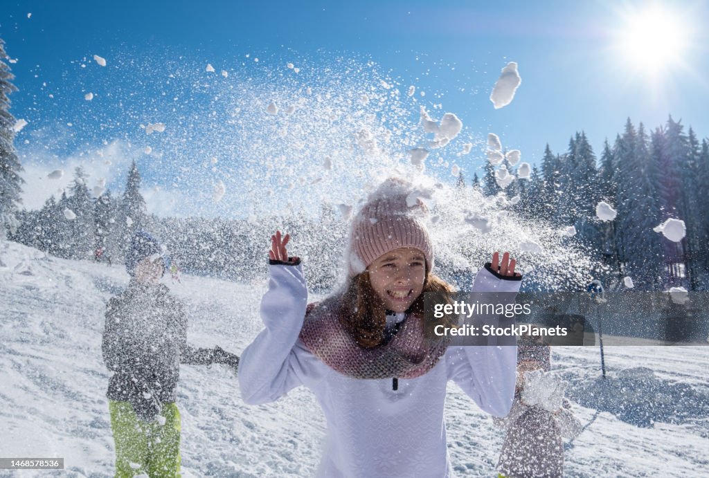Brothers throw snowballs at sister.