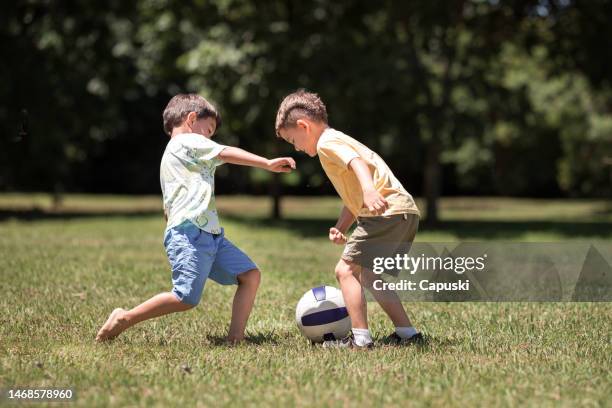 boys playing soccer at the park - brazil and outside and ball stock pictures, royalty-free photos & images
