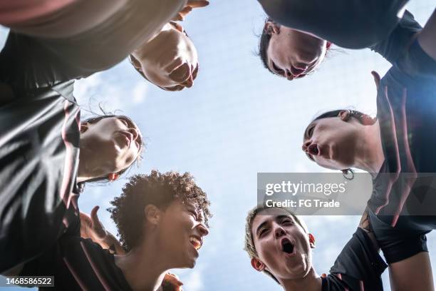female soccer team huddling in the field - representing stock pictures, royalty-free photos & images