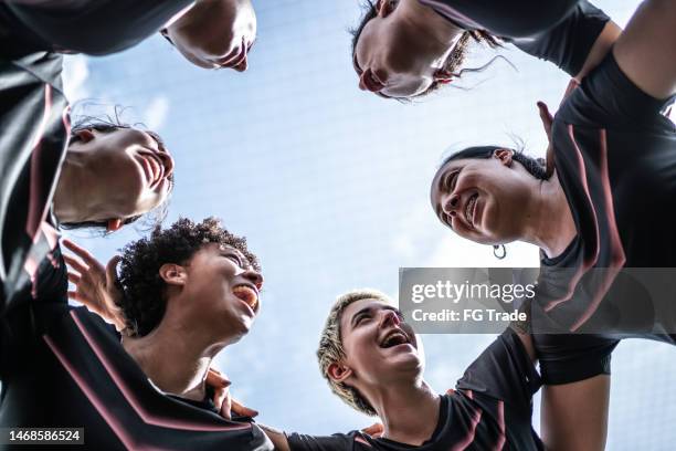 squadra di calcio femminile che si stringe nel campo - dedizione foto e immagini stock