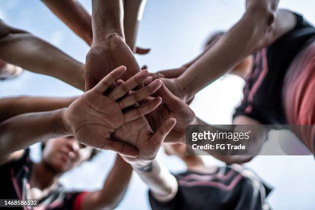close-up of female soccer team stacking hands in the field - huddling stock pictures, royalty-free photos & images