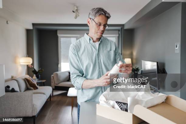 mature man unpacking online ordered items - customised stock pictures, royalty-free photos & images