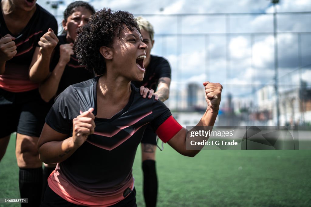 Excited female soccer celebrating in the field