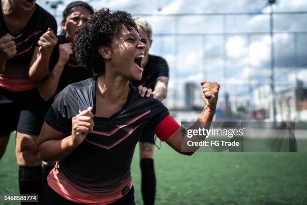 excited female soccer celebrating in the field - anfallsspelare fotboll bildbanksfoton och bilder