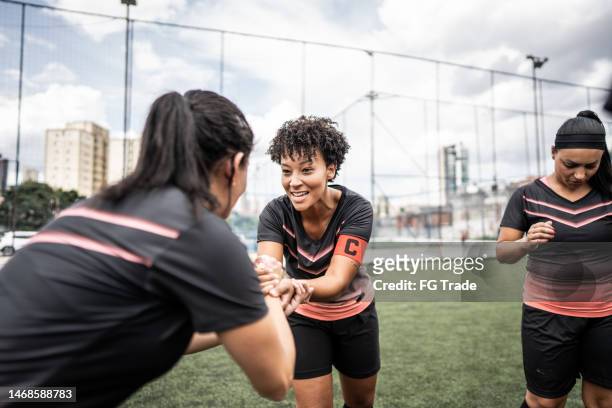 la capitana del equipo de fútbol femenino anima a su colega antes del partido - team captain fotografías e imágenes de stock