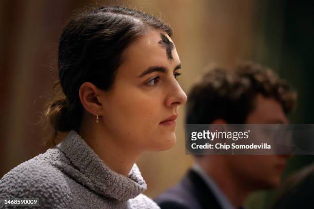 With a cross of ash on her forehead, a woman prays during an Ash Wednesday Mass at the Cathedral of St. Matthew the Apostle on February 22, 2023 in...