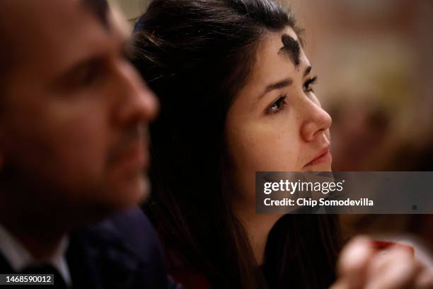 With a cross of ash on her forehead, a woman attends an Ash Wednesday Mass at the Cathedral of St. Matthew the Apostle on February 22, 2023 in...