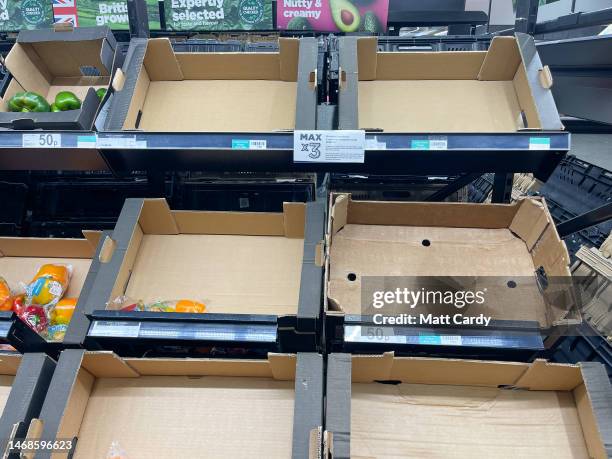 Empty shelves and boxes are seen alongside fruit and vegetables that are being are offered for sale inside a branch of the supermarket retailer Asda...