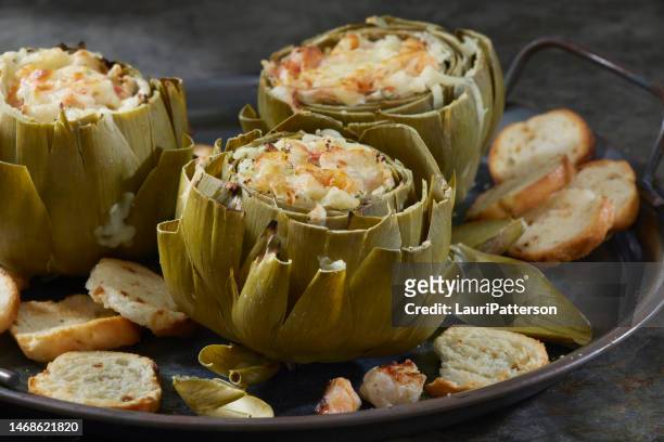 hot, creamy baked crab and shrimp stuffed artichokes - appetizers stock pictures, royalty-free photos & images