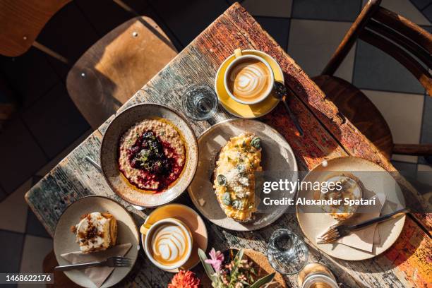 breakfast with scrambled egg, porridge and cinnamon buns served in a cafe - roerei stockfoto's en -beelden