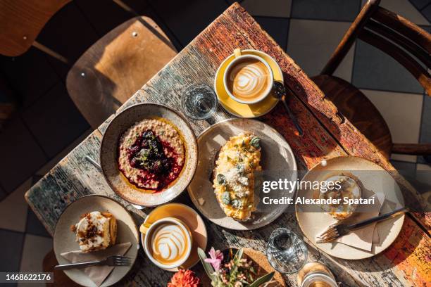 breakfast with scrambled egg, porridge and cinnamon buns served in a cafe - empty prague stock pictures, royalty-free photos & images