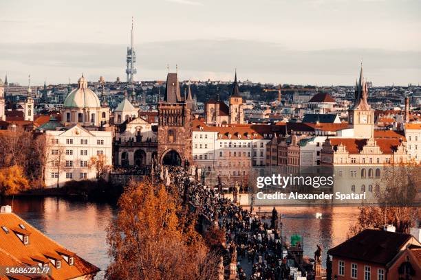 prague skyline with charles bridge and crowds of tourists, czech republic - prague tourist stock pictures, royalty-free photos & images