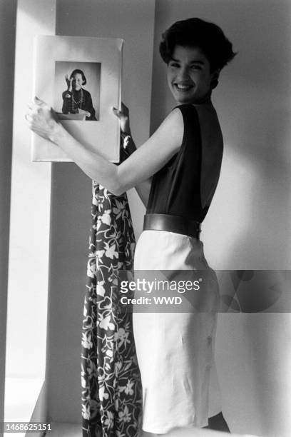 Model Janice Dickinson poses with a hardcover copy of Allure by Diana Vreeland.