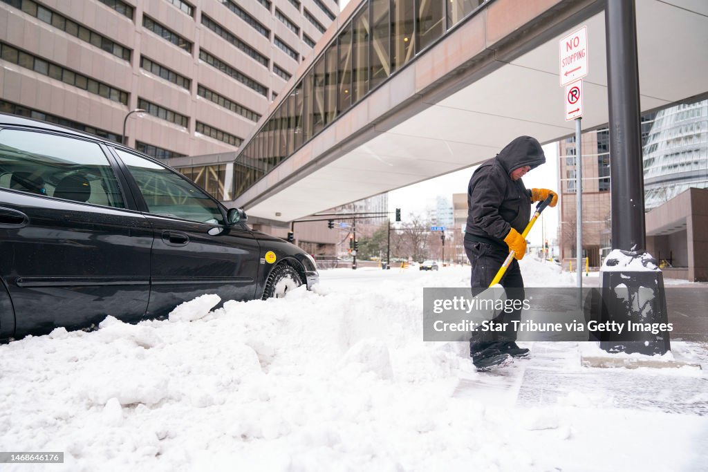 Minnesota February Luis Lara clears snow off of sidewalks Wednesday, Feb. 22, 2023 in ...