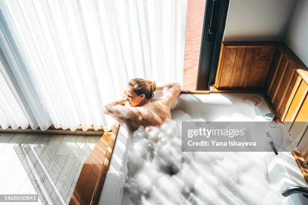 beautiful young woman is relaxing in a hot tub, taking time for herself - luxury break ストックフォトと画像