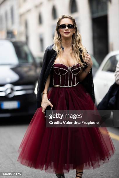 Michela Persico is seen wearing black Balenciaga sunglasses, a black leather jackets, a burgundy corset embroidered with rhinestones and a burgundy...