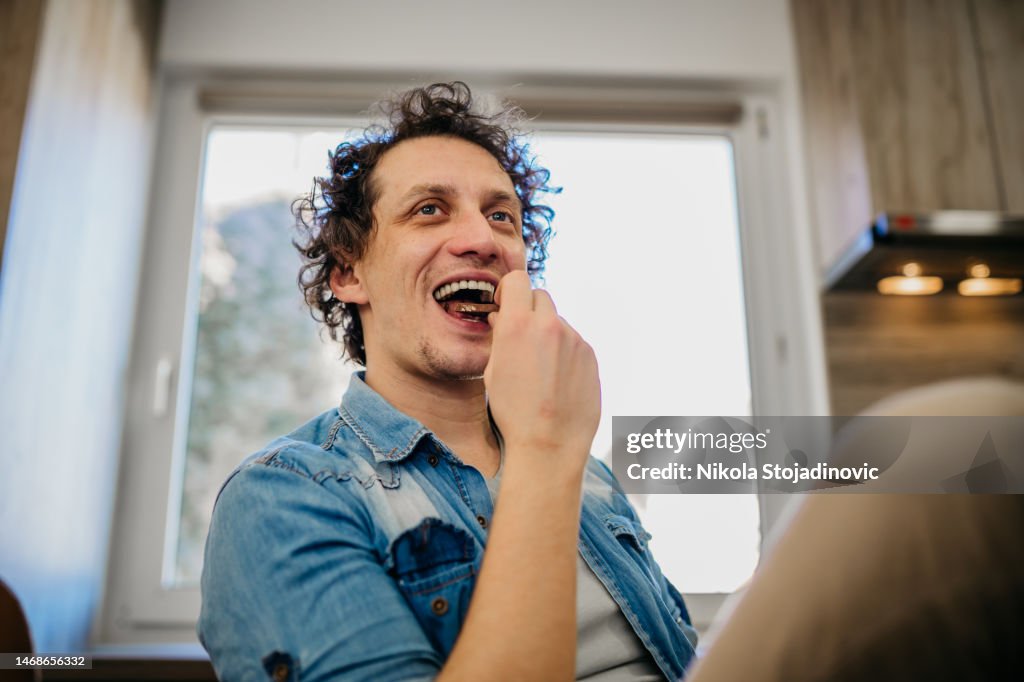 Young handsome man eating chocolate bar