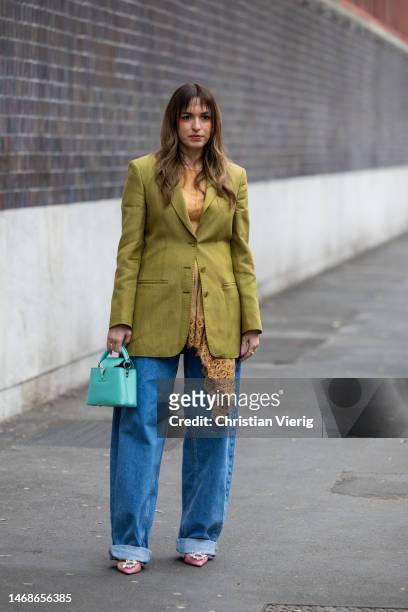 Camila Carril is seen wearing green blazer, denim jeans, turquoise Louis Vuitton bag, laced top outside Alberta Ferretti during the Milan Fashion...