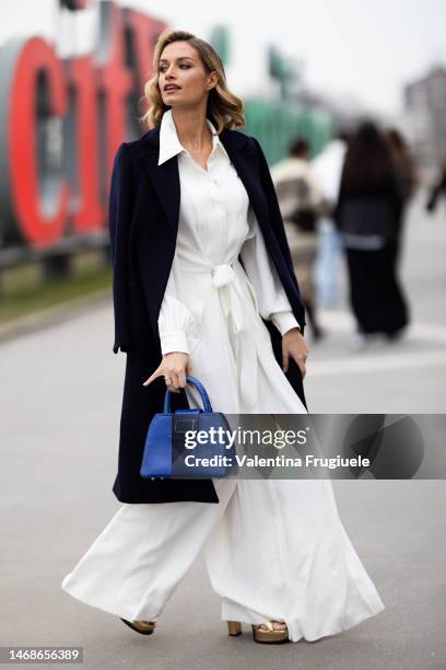 Actress Giulia Arena is seen wearing wide white pants and shirt, blue coat and blue bag outside the Alberta Ferretti show during the Milan Fashion...