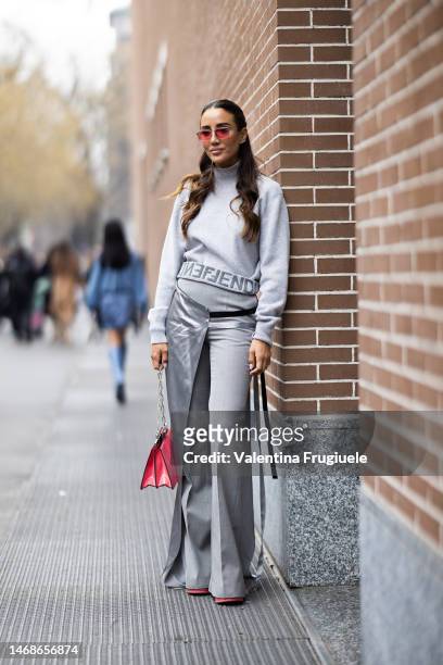 Tamara Kalinic is seen wearing peach sunglasses, gold and diamond earrings, a light grey turtleneck sweater with grey lettering Fendi logo at the...