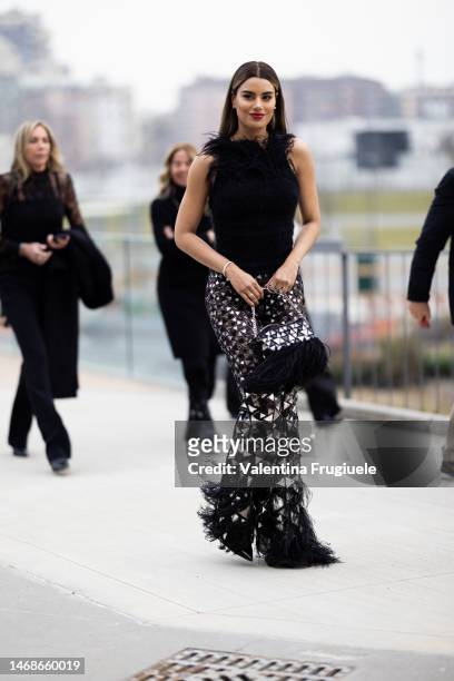 Guest is seen wearing fringes pants embellished with triangles, a fringed bag and feathers top outside the Alberta Ferretti show during the Milan...