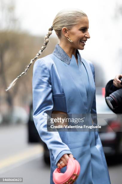 Caroline Daur is seen wearing gold pendant earrings from Tiffany, a pale blue silk cut-out long coat from Fendi, a pink shiny leather small...