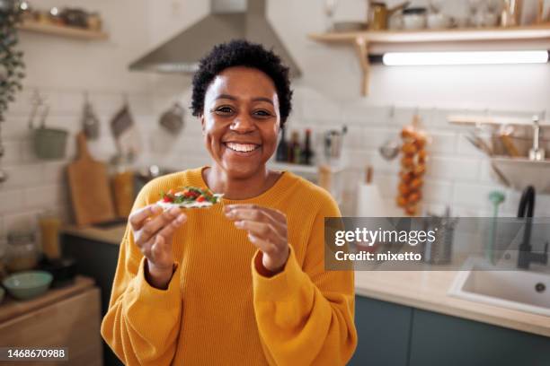 ritratto di giovane bella donna sorridente in una cucina domestica - stuzzicare foto e immagini stock