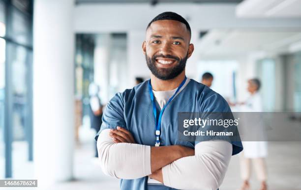 nurse, hospital employee and portrait of black man in a healthcare, wellness and clinic feeling proud. happy, smile and doctor in a medical facility with happiness from workplace vision and success - medical scrubs stock pictures, royalty-free photos & images